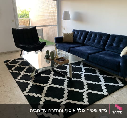 ספה כחולה עם כריות על שטיח שחור לבן